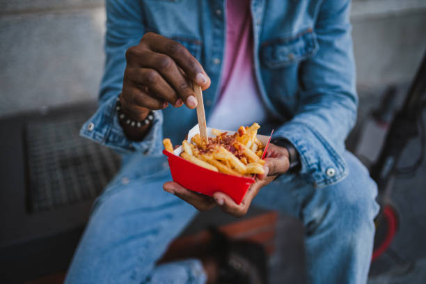 istock Man taking fries with bacon and cheddar 1460046529