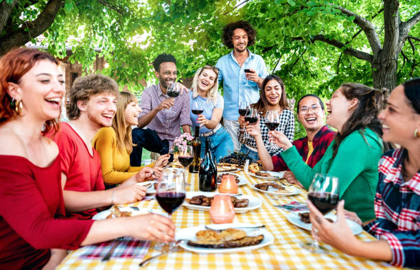 happy people having fun toasting wine out side farm house - young friends sharing harvest together at vineyard countryside - youth life style concept - shallow depth of field with focus on middle - picnic family barbecue social gathering imagens e fotografias de stock