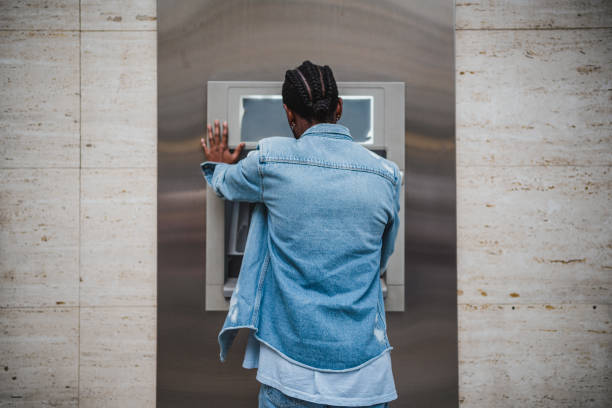 istock Man using a ATM to withdrawal money 1460046670