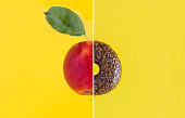 Collage of donut with chocolate glaze and red apple on the yellow background. Copy space.