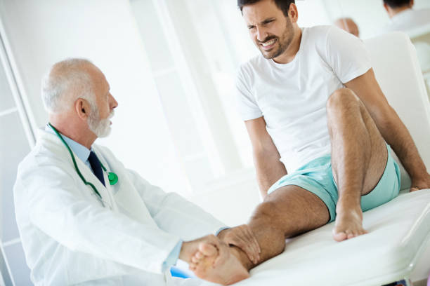 istock Young man having his ankle examined by a doctor. 1460047757