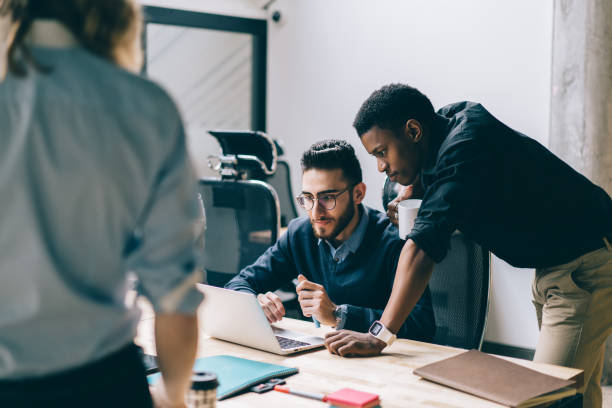 istock Focused black employee looking at laptop working with partner 1460047786