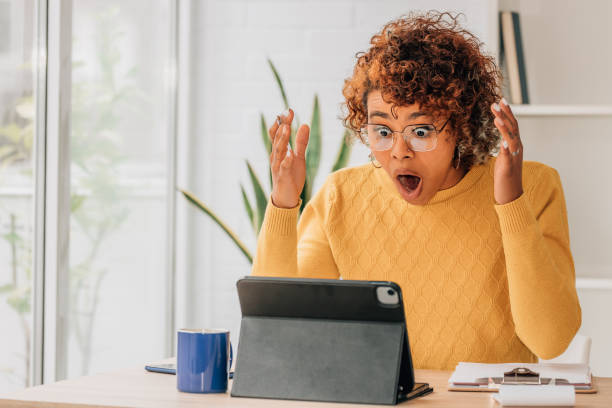 istock woman with surprised expression looking at laptop or computer 1460049071