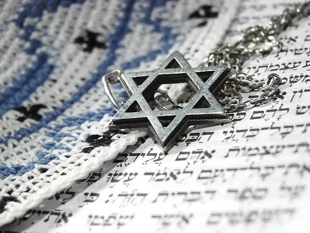 Jewish religious symbols - star of David, Torah hebrew, yarmulke - closeup.