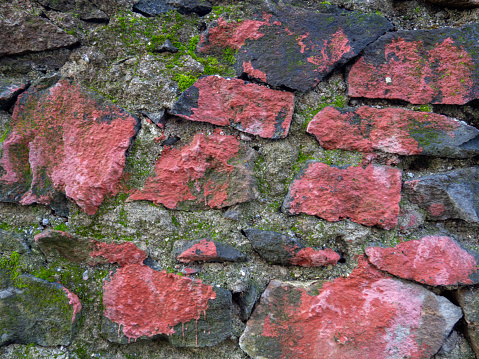 Vintage masonry red stone. Old wall made of rough stones. Background of solid red material. ancient architecture