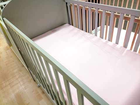 A view of an empty baby's crib in a department store setting.