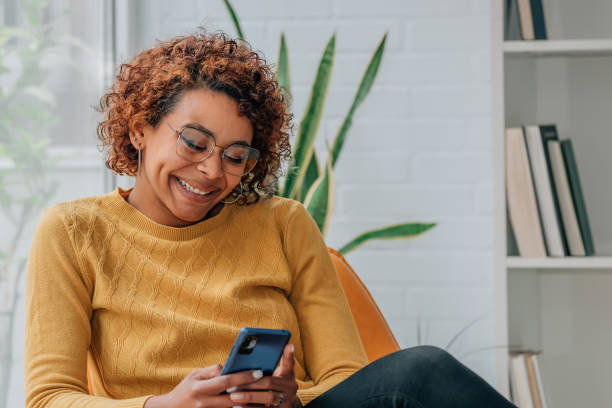 istock girl at home looking at mobile phone smiling 1460057169