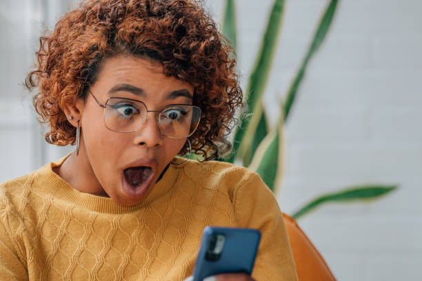 istock girl at home looking at mobile phone surprised 1460057173