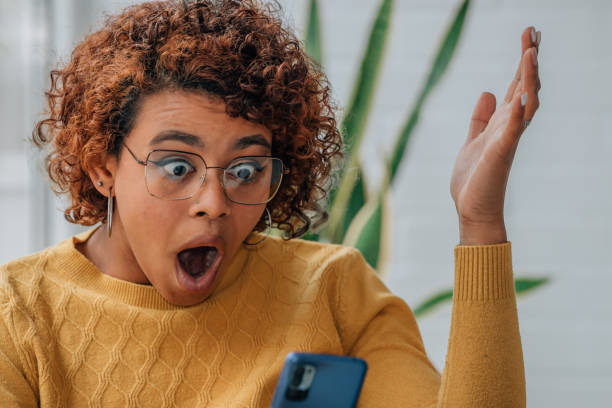 istock girl at home looking at mobile phone surprised 1460057174