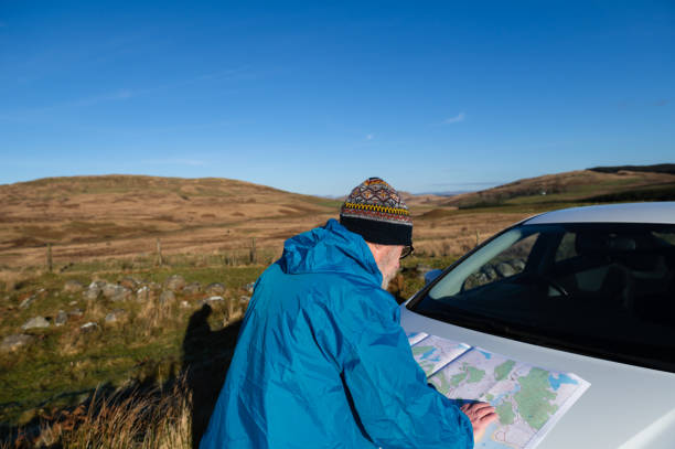 istock Senior man studying a map on a car bonnet 1460060615