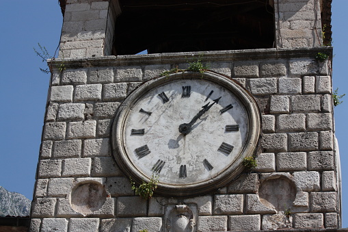 white clock on an old medieval tower in Montenegro