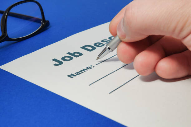 Job Description with Hand and Pen on blue background close up.