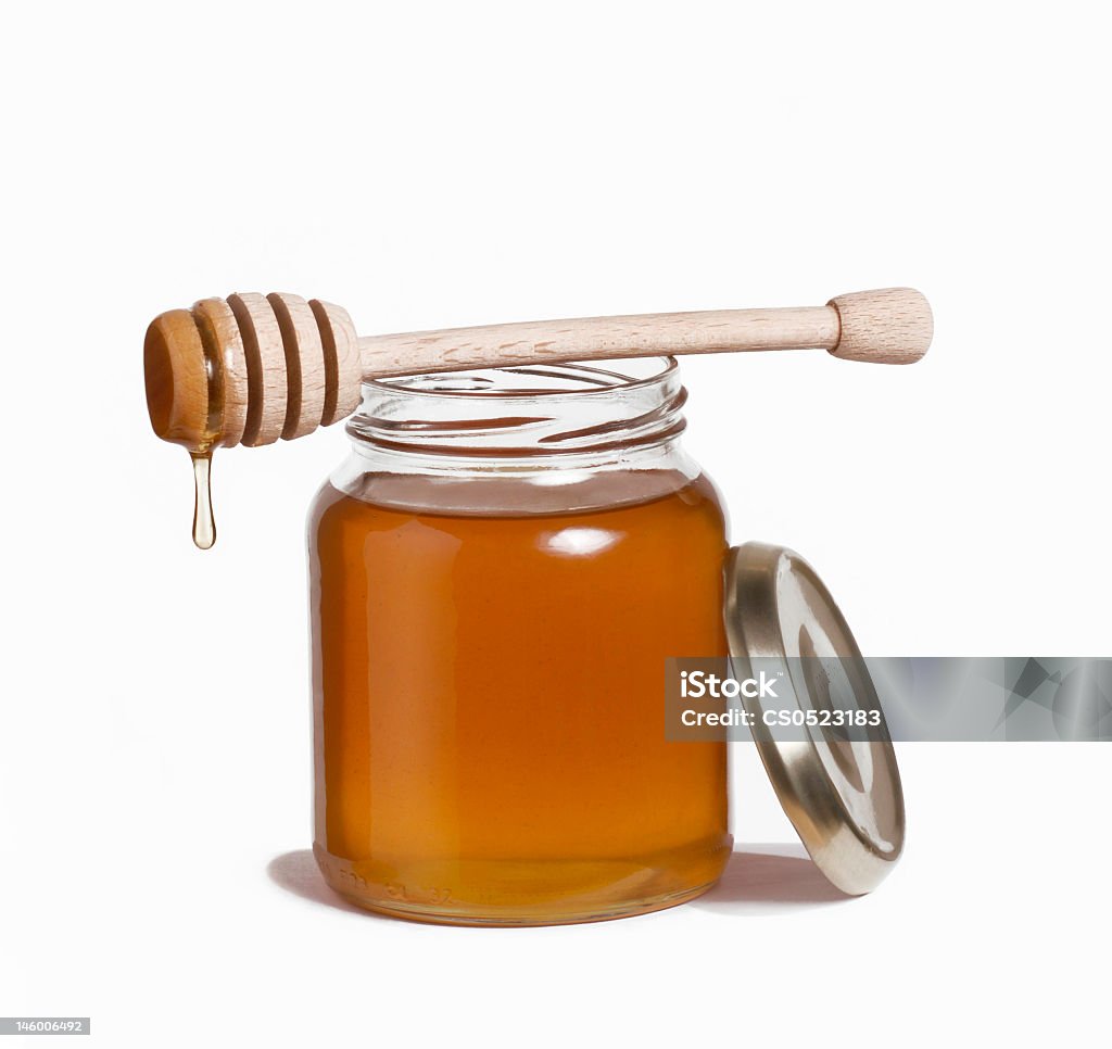 Glass honey pot and dipper with honey drop on white background. Honey pot and dipper. Cut Out Stock Photo