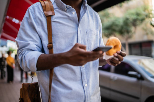 istock Close-up of young man using mobile phone while walking outdoors 1460066582