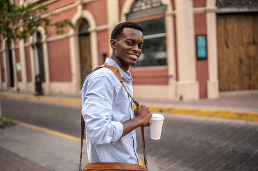 Portrait of young businessman walking at the historic district