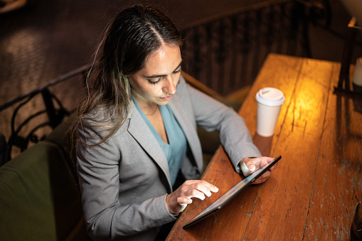 Mid adult woman using digital tablet on a coffee shop