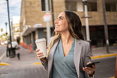 Mid adult businesswoman looking away holding coffee cup outdoors