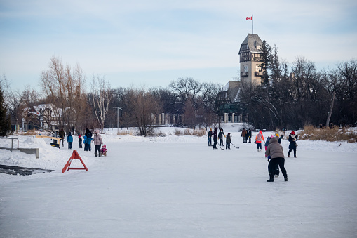Winnipeg Manitoba Canada - January 22nd 2023 / A large group of people have gathered together at the Assiniboine park to have a fun day of skating at frozen duck pond