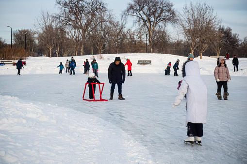 Winnipeg Manitoba Canada - January 22nd 2023 / A large group of people have gathered together at the Assiniboine park to have a fun day of skating at frozen duck pond