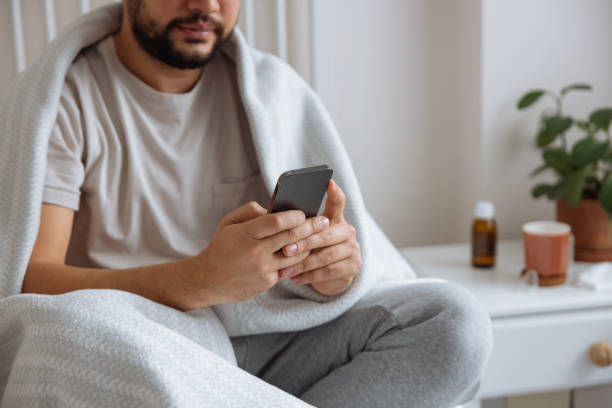 istock Sick man with the flu speaking to a virtual doctor 1460072730