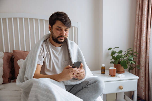 Sick man with the flu speaking to a virtual doctor