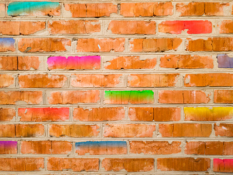 Texture of an old brick wall with stylized colorful bricks. Original illustration of a wall made of red, yellow, turquoise, blue, light green, purple gradient bricks. For designers