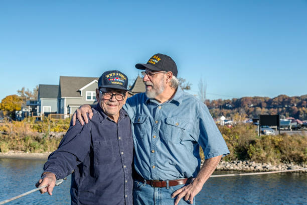 un vétéran de la guerre du vietnam des états-unis taquine un vétéran militaire plus âgé de la seconde guerre mondiale - sailor people personal accessory hat photos et images de collection
