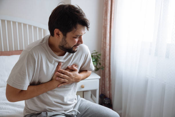 Heart attack, man with chest pain suffering at home stock photo