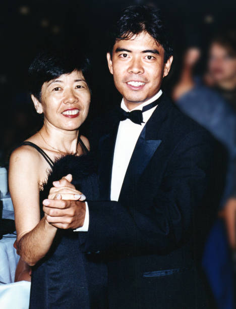 젊은 성인 아들과 함께 대학 졸업을 축하하는 중년의 어머니 - 20th century style flash 뉴스 사진 이미지