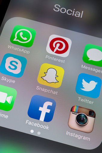 The Snapchat App on a cellphone screen, surround by the Apps of Whatsapp, Pinterest, Messages, Skype, twitter, Facetime, Facebook and Instagram