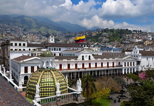 A view of the centre of the town and it's colonial buildings,  of Antigua, a famous and popular destination for travellers and backpackers, deserted of people - and in the background the Acatenango volcano, rising above the clouds.