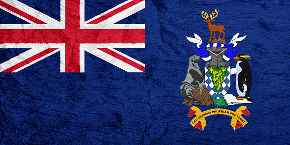 Flag of the British Overseas Territory of the South Georgia and the South Sandwich Islands on a textured background. Concept collage.