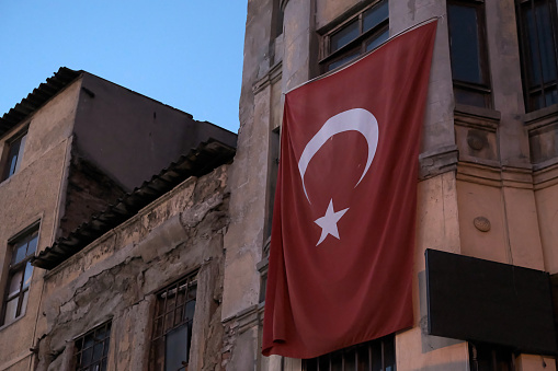 Flag of Turkey hanging on a shabby building.