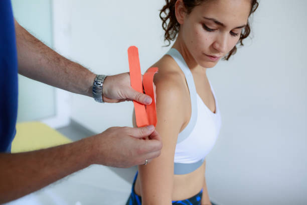 istock Physiotherapist applying adhesive tape on a female patient, shoulder area 1460091908