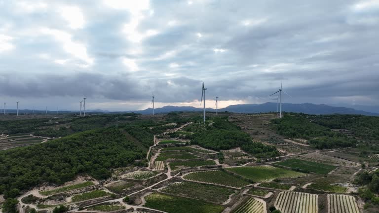 Dramatic landscape and clouds with wind turbines not moving on the horizon