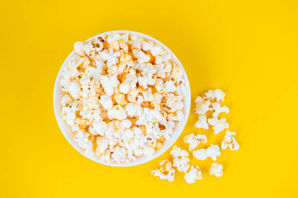 istock Scattered tasty cheese popcorn in bowl isolated on yellow background 1460102936