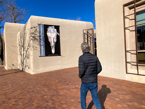 Santa Fe, NM: A man outside the Georgia O’Keeffe Museum in downtown Santa Fe, NM on a sunny day.