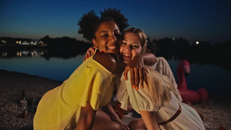 SLO MO Two young women embraces and poses on the beach at blue hour