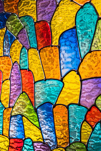 Close up image of window featuring beveled and textured glass distorting the view.