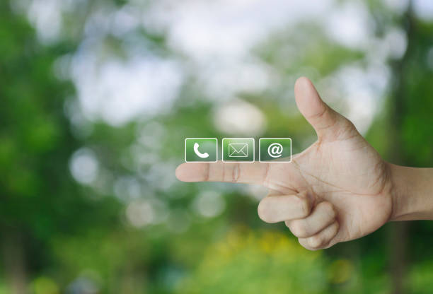 Telephone, mail, email address icon on finger over blur green tree in park, Business customer service and support online concept