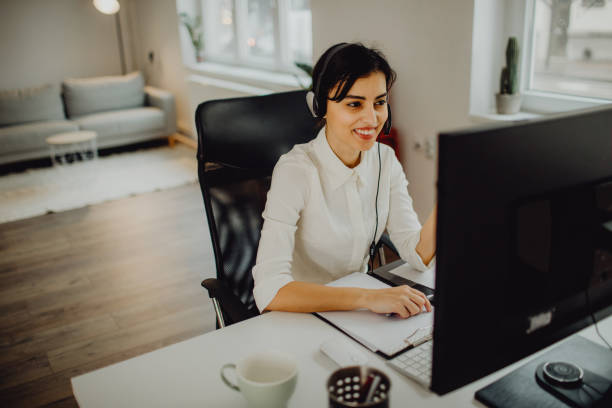 istock Smiling young female call center agent working in her office 1460117300