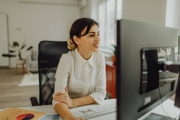 istock Smiling young businesswoman working on a computer in her office 1460117404