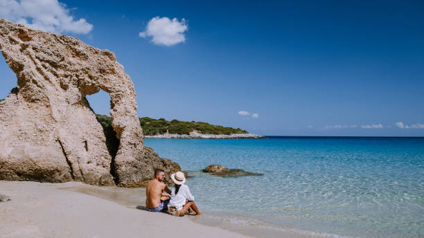 paar besuchen den tropischen strand von voulisma strand, istron, kreta, griechenland während des urlaubs - agios nikolaos stock-fotos und bilder