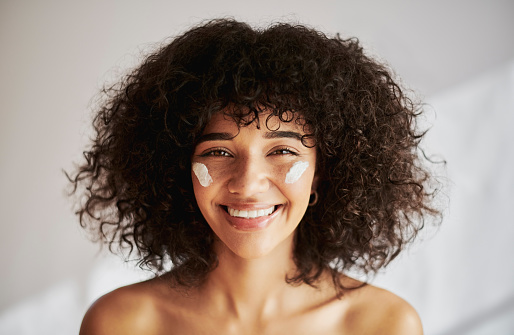 Black woman, beauty portrait and happy about skincare cream with dermatology cosmetics product. Face and smile of a model in studio for skin glow, natural hair and self care facial collagen cosmetic