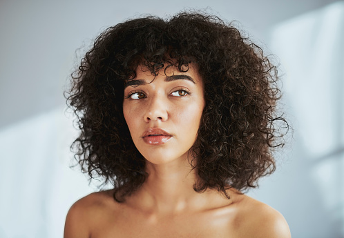 Face, beauty and thinking with a black woman in studio to promote natural skincare or treatment. Facial, skin and idea with an attractive young female model posing for wellness or aesthetic