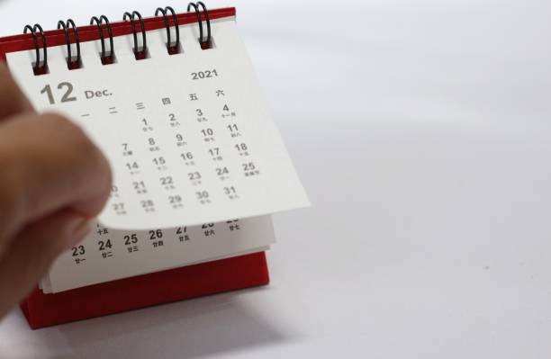 istock hand going to flip calendar paper white background 1460129104