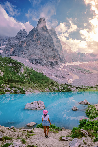 women hiking to the Lago di Sorapis lake in the Italian Dolomites, milky blue lake Lago di Sorapis, Lake Sorapis, Dolomites, Italy.