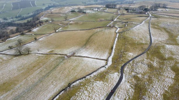 istock Aerial view of three hikers walking along minor road in Winter, Stainforth, Craven, Yorkshire Dales National Park, North Yorkshire, England, Britain 1460144708