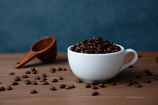 roasted coffee beans in coffee cup on table