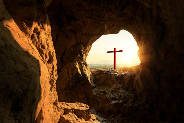 istock Empty cemetery with crucifixion at sunset from cave mouth 1460148754